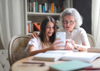 Persona mayor usando tablet con ayuda de familiar
