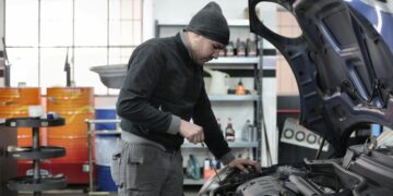 Persona realizando mantenimiento del motor de un coche