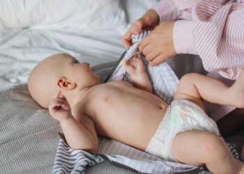 Madre porteando a su bebé de forma ergonómica