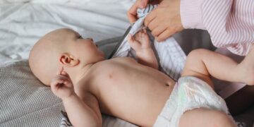 Madre porteando a su bebé de forma ergonómica