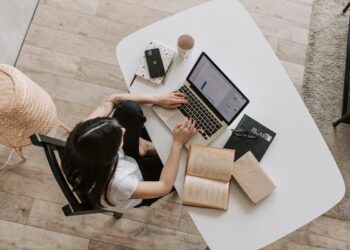 Persona trabajando con portátil en escritorio de casa