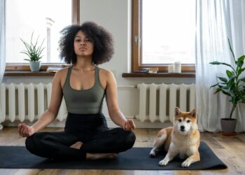 Mujer practicando yoga en casa sobre esterilla